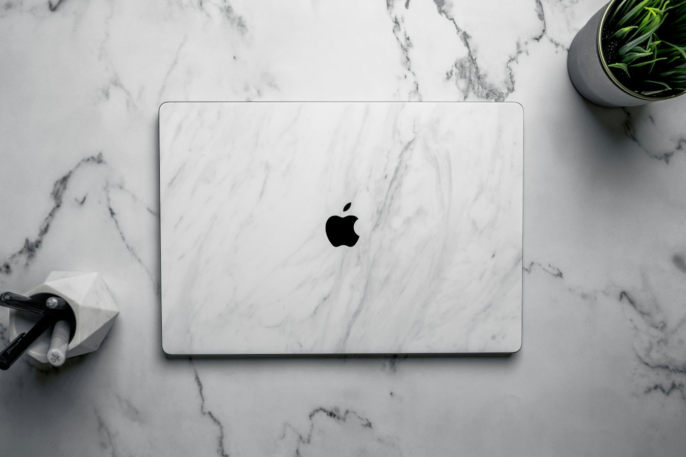 Laptop na białym biurku podczas optymalizacji wizytówki